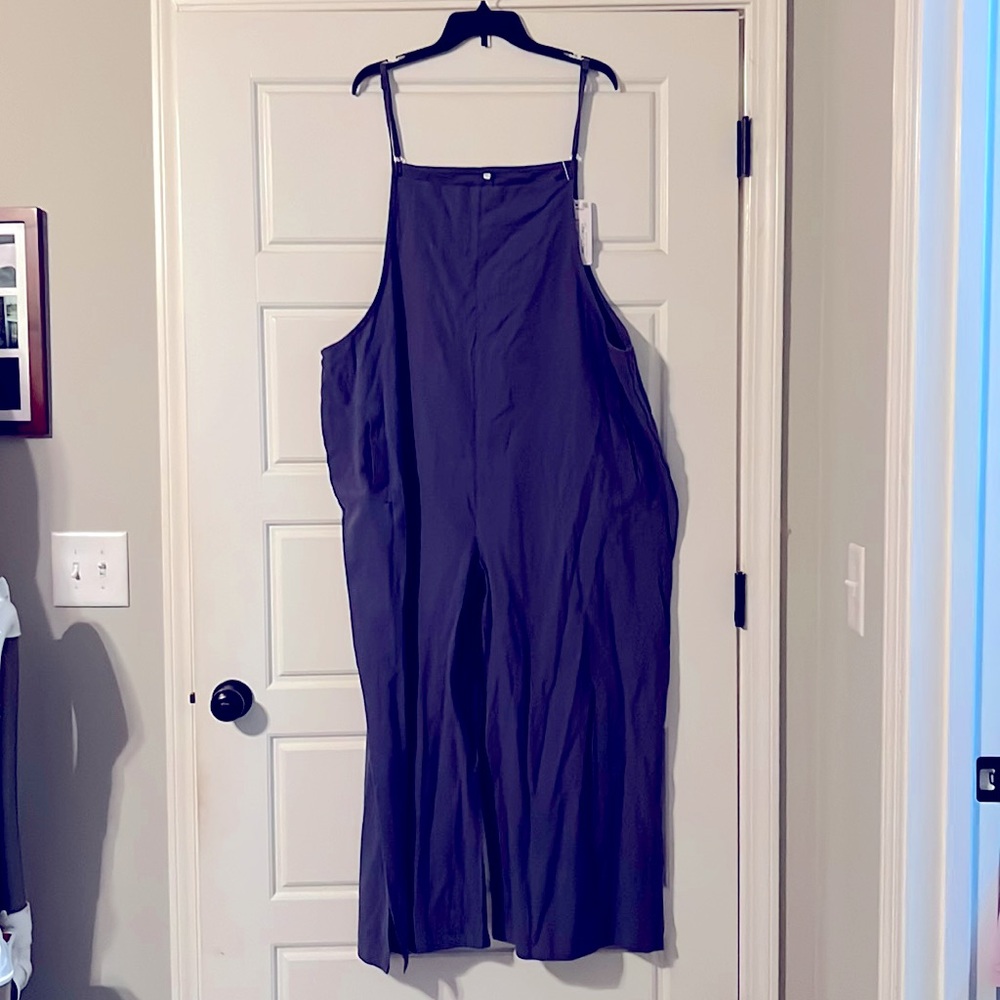 Loose fit jumper. It has pockets, adjustable straps, and split at hem. NWT